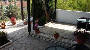 a patio with potted plants next to a fence at Dasea Houses in Ormos Panagias