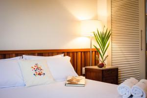 a bedroom with a bed with a book on it at Pousada Casa da Vitória in Salvador