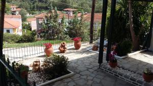 a balcony with several flower pots on a patio at Dasea Houses in Ormos Panagias