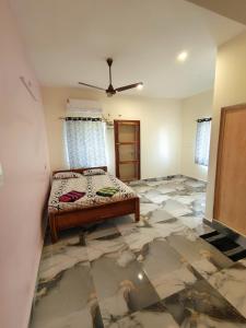 Un dormitorio con una cama y suelo de baldosas. en Poornima home stay, en Tiruvannāmalai