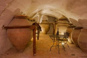 a room with a table and large vases in a cave at Casa Palacio Conde de Garcinarro in Huete