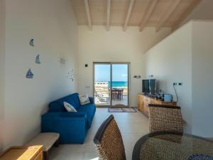 a living room with a blue couch and a view of the ocean at Casa Ammos in Platamona