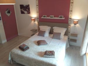 a bedroom with a white bed with a red wall at Chambre d'hôte Le Clos d'Audio à Riols in Riols +11 photos