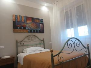 a bedroom with a bed and a painting on the wall at Casa Vacanza Dante Alighieri, B in Moscufo
