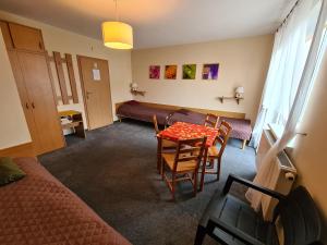 a room with a bed and a table and chairs at Willa Helios in Władysławowo