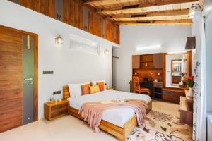 une chambre avec un grand lit et une cuisine dans l'établissement SaffronStays The Mountain Escape, à Mukteswar 54 autres photos