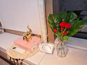 a table with a vase of flowers and a vase of roses at Healing Space Just 3 Min from Myeonghak St in Anyang