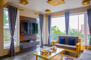 un salon avec un canapé et une télévision dans l'établissement SaffronStays The Mountain Escape, à Mukteswar