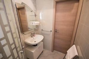 a small bathroom with a sink and a mirror at Apartments Lidija in Umag