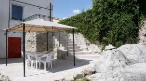 a table and chairs under an umbrella next to some stairs at Casa Elvira Basilico in Scafa