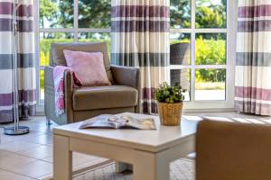 ein Wohnzimmer mit einer Couch und einem Tisch in der Unterkunft Residenz am Balmer See - BS 37H mit Wellnessbereich in Balm