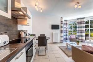 eine Küche und ein Wohnzimmer mit einer Couch und einem Tisch in der Unterkunft Residenz am Balmer See - BS 37H mit Wellnessbereich in Balm