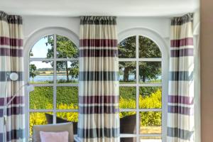 Zimmer mit 3 Fenstern und Blick auf das Wasser in der Unterkunft Residenz am Balmer See - BS 37H mit Wellnessbereich in Balm