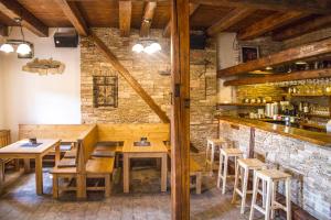 a restaurant with wooden tables and chairs and a brick wall at Restaurace & Penzion U Tří Jasanů in Znojmo