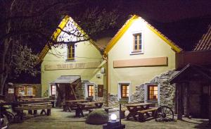 a building with picnic tables in front of it at night at Penzion U Tří Jasanů in Znojmo