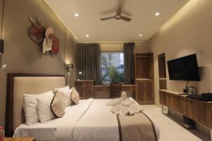 a bedroom with a large bed and a television at Balaji Seven Hills in Jaipur