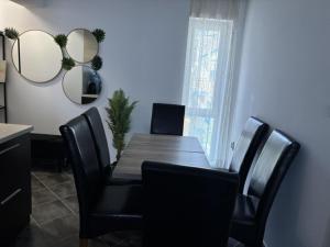a dining room with a wooden table and black chairs at Divine place Pomorie in Pomorie +3 photos