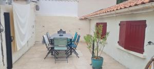 a table and chairs on a patio with a potted plant at Maison de Campagne cosy in Pons +14 photos