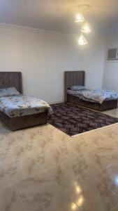 deux lits dans une chambre avec un sol carrelé dans l'établissement استراحه الحياه, à Yanbu