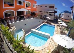 a swimming pool in front of a house at Hotel Areia de Ouro in Natal