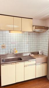 a kitchen with white cabinets and a sink at Skytree Residence 錦糸町 駅から600M徒歩8分 in Tokyo