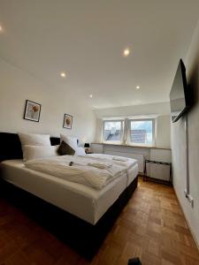 a bedroom with a large bed and two windows at Deluxe Apartment in Jettingen-Scheppach