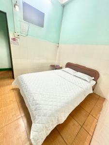 a bedroom with a bed with a white comforter at BB Tài Thịnh in Quảng Ngãi +12 photos