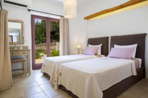 1 dormitorio con 2 camas con almohadas rosas y espejo en Amapola Boutique Villas with Sea Access - Phos, en Sivota 50 fotos más