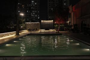 a swimming pool in a city at night at Balaji Seven Hills in Jaipur