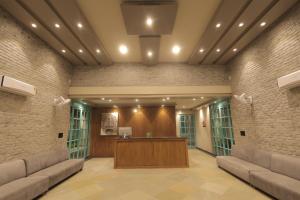 an office lobby with a reception desk and brick walls at Balaji Seven Hills in Jaipur