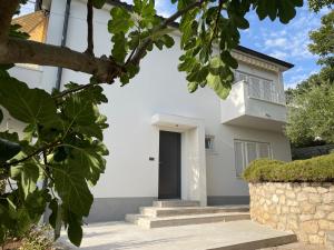 a white house with a black door at Apartments No26 in Povile