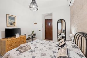 a bedroom with a bed and a dresser and a television at Dimora del Chiostro in Oristano