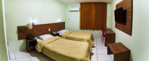 um quarto de hospital com duas camas e uma mesa em Belém Soft Hotel em Belém