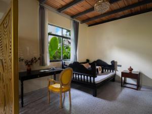 a living room with a couch and a table and a window at 22 Garden House in Jinghong