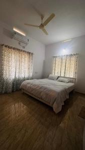a bedroom with a bed and two large windows at Niel Valley Homestay - Poomala in Mulagunnathukāvu