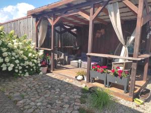 a wooden pergola with a bench and flowers at Apartments near old town with private parking in Kaunas
