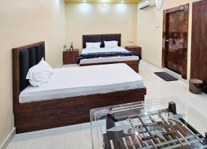 a bedroom with two beds and a glass window at Ojas Royale - Banquet and Hotel in Prayagraj +18 photos