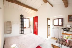 a bedroom with a white bed and a red door at Casa Elvira Basilico in Scafa