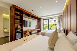 a hotel room with two beds and a television at Em's House Hoi An Homestay 2 in Hoi An +51 photos