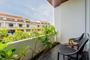 a balcony with chairs and a view of a building at Em's House Hoi An Homestay 2 in Hoi An