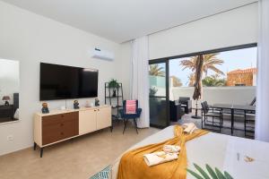 a bedroom with a bed with a television and a balcony at Apartamento Praia Santa Maria in Santa Maria