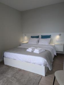 Un dormitorio con una cama blanca con toallas. en Monte Gordo Accommodation, en Ribeira Brava