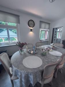 a dining room with a table with chairs and a clock at Osada Narost 37 in Chojna