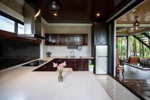 a kitchen with a vase of flowers on a table at Domnak Pichet in Siem Reap +30 photos