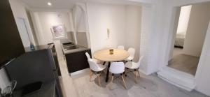 a dining room with a table and white chairs at Le Central in Villeneuve-sur-Yonne