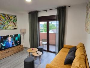 a living room with a couch and a tv at Skitnica U Prolazu in Koprivnica