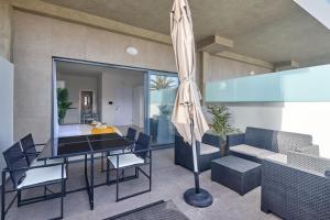 a dining room with a table and chairs and an umbrella at Apartamento Praia Santa Maria in Santa Maria