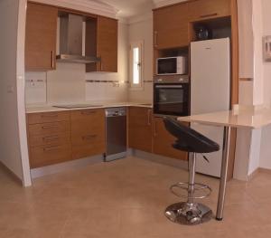 a kitchen with a table and a black chair in it at Acogedor y excelente ubicación in Puerto de Sagunto