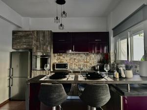 Eine Küche mit einer Kücheninsel und zwei Barhockern in der Unterkunft Valla Studio in Rhodos (Stadt)