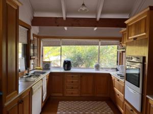 a kitchen with wooden cabinets and a large window at Farm-stay delight in Gong Gong